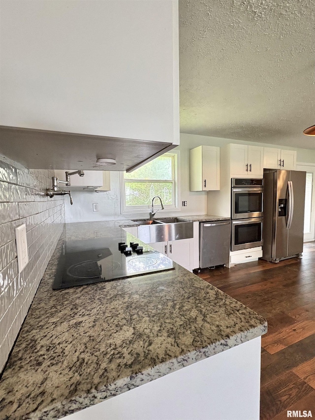 910 Fairlane Dr, Marion, IL 62959 - kitchen featuring appliances with stainless steel finishes, a sink, white cabinetry, dark wood-style floors, and backsplash