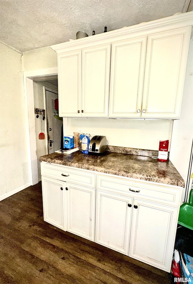 1105 N Maple St, Carterville, IL 62918 - kitchen with dark wood-style flooring, a textured ceiling, white cabinets, and baseboards