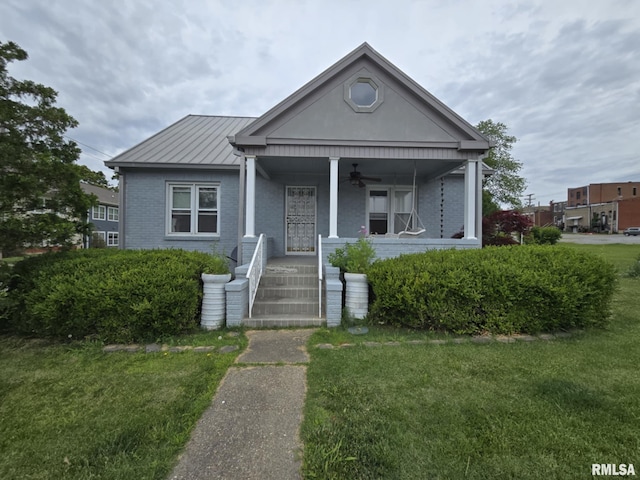 112 W Main St, Mcleansboro, IL 62859 - view of front of home featuring a ceiling fan, a porch, a front lawn, brick siding, and a standing seam roof