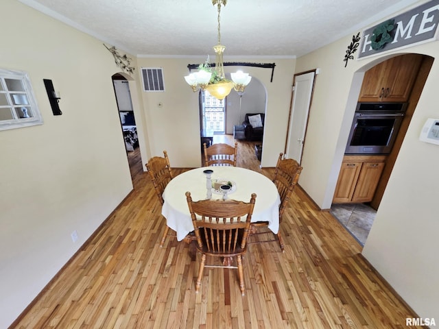 112 W Main St, Mcleansboro, IL 62859 - dining room with arched walkways, light wood-type flooring, and a chandelier