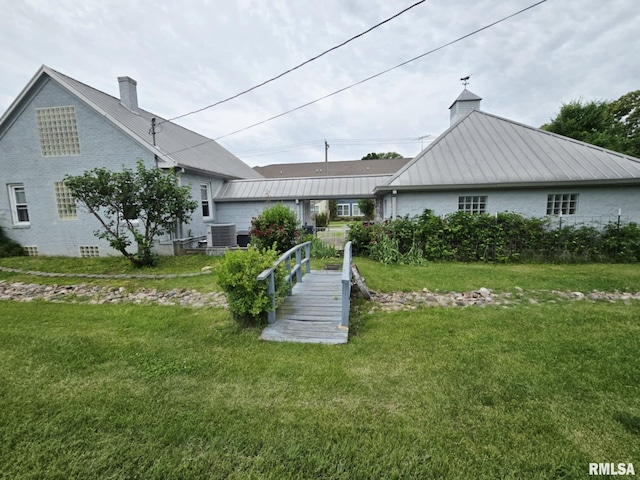 112 W Main St, Mcleansboro, IL 62859 - back of property with a chimney, cooling unit, a lawn, metal roof, and a standing seam roof