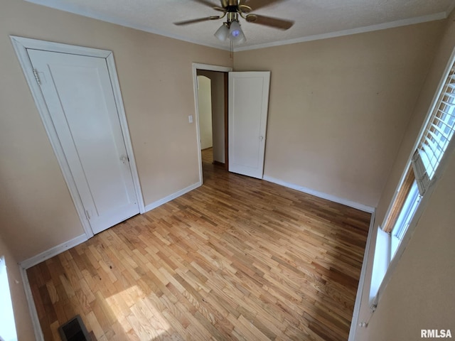 112 W Main St, Mcleansboro, IL 62859 - unfurnished bedroom with light wood-style floors, ornamental molding, baseboards, and ceiling fan