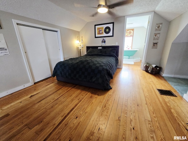 112 W Main St, Mcleansboro, IL 62859 - bedroom with vaulted ceiling, hardwood / wood-style flooring, a textured ceiling, a closet, and a ceiling fan