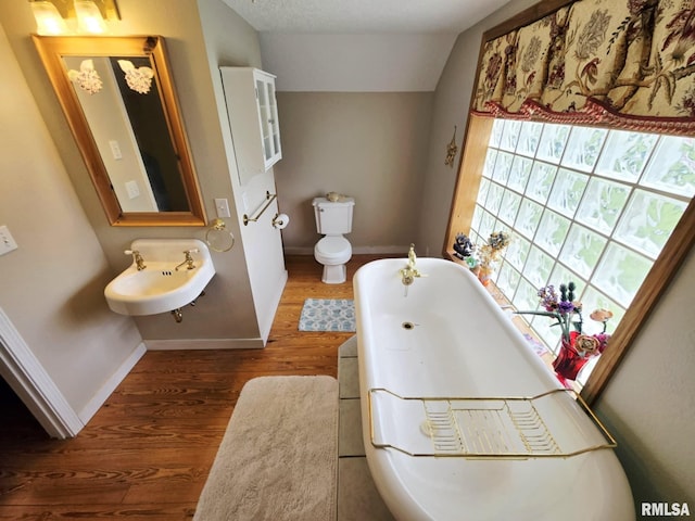 112 W Main St, Mcleansboro, IL 62859 - full bath with a freestanding tub, baseboards, wood finished floors, a sink, and vaulted ceiling