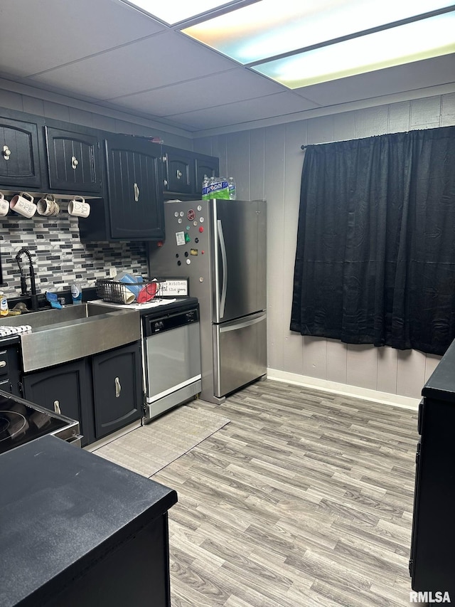 527 E Lawrence St, Benton, IL 62812 - kitchen featuring dishwashing machine, dark countertops, light wood finished floors, backsplash, and freestanding refrigerator
