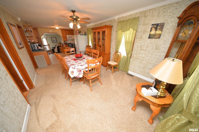 12522 N Dartmouth Ln, Mount Vernon, IL 62864 - dining area with arched walkways, wallpapered walls, a ceiling fan, ornamental molding, and light colored carpet