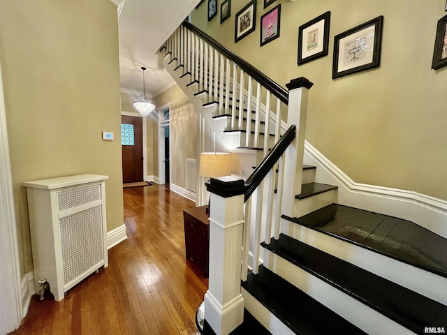 212 E 3rd St, Metropolis, IL 62960 - stairs featuring wood-type flooring, baseboards, ornamental molding, and a chandelier