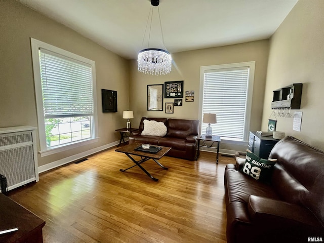 212 E 3rd St, Metropolis, IL 62960 - living area with a chandelier, wood finished floors, baseboards, radiator heating unit, and heating unit