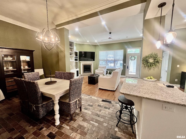 212 E 3rd St, Metropolis, IL 62960 - dining room with a fireplace, ornamental molding, a chandelier, ceiling fan, and brick patterned flooring
