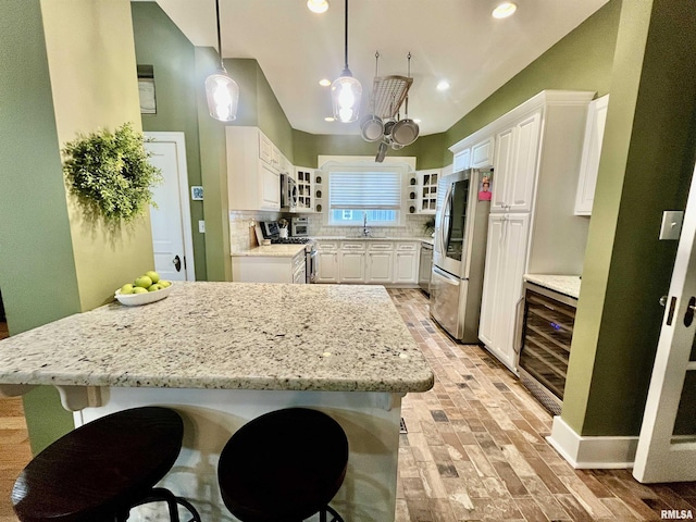 212 E 3rd St, Metropolis, IL 62960 - kitchen featuring stainless steel appliances, wine cooler, a kitchen breakfast bar, a sink, and glass insert cabinets