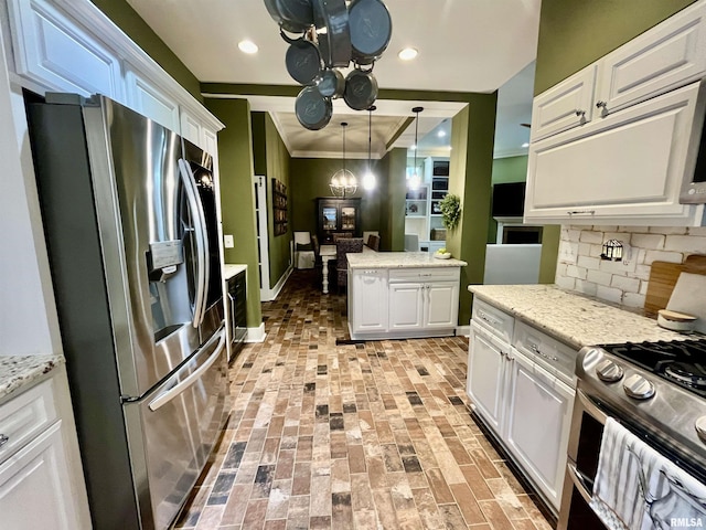 212 E 3rd St, Metropolis, IL 62960 - kitchen featuring stainless steel appliances, white cabinetry, brick floors, decorative backsplash, and ornamental molding