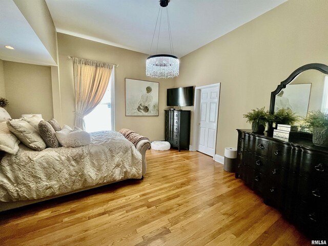 212 E 3rd St, Metropolis, IL 62960 - bedroom featuring light wood-style flooring and a chandelier