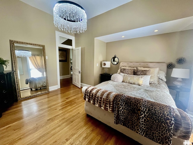212 E 3rd St, Metropolis, IL 62960 - bedroom with wood finished floors, a high ceiling, baseboards, a chandelier, and baseboard heating