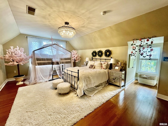 212 E 3rd St, Metropolis, IL 62960 - bedroom with wood finished floors, baseboards, vaulted ceiling, and multiple windows