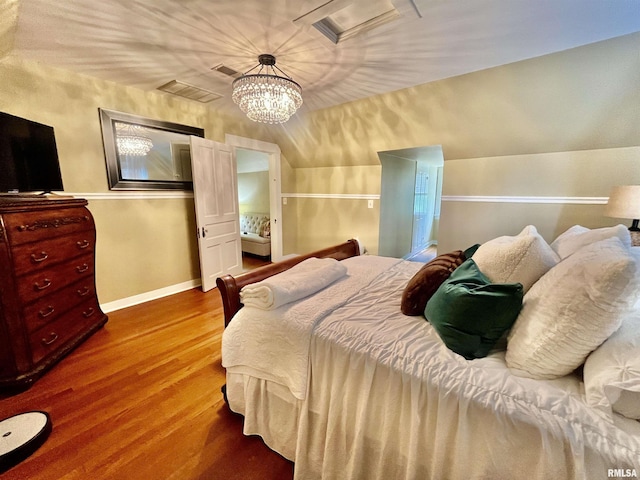 212 E 3rd St, Metropolis, IL 62960 - bedroom with lofted ceiling, wood finished floors, and a chandelier