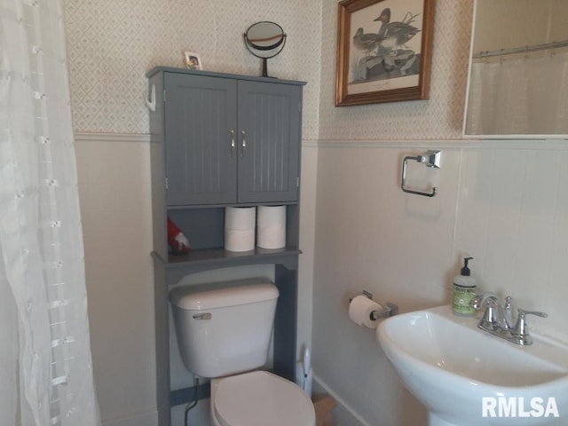 504 W Sylvester Ave, Christopher, IL 62822 - full bathroom featuring a sink, a wainscoted wall, wallpapered walls, toilet, and curtained shower