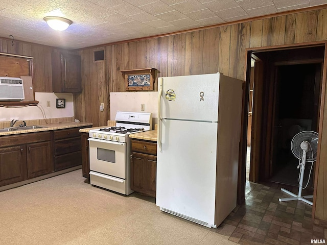 1502 N 13th St, Herrin, IL 62948 - kitchen with white appliances, wood walls, a sink, light countertops, and a wall mounted air conditioner