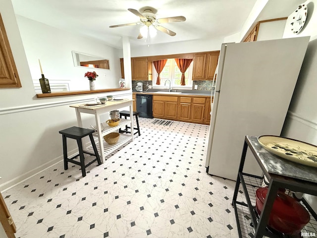1300 S Duncan St, Marion, IL 62959 - kitchen with black dishwasher, freestanding refrigerator, a sink, a ceiling fan, and brown cabinets