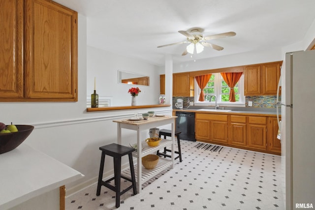 1300 S Duncan St, Marion, IL 62959 - kitchen featuring freestanding refrigerator, dishwasher, a sink, brown cabinetry, and a wainscoted wall
