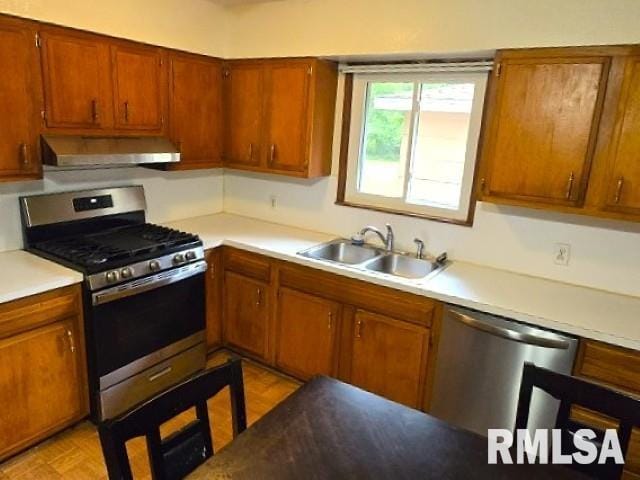 415 Marteeny St, Mount Vernon, IL 62864 - kitchen with stainless steel appliances, wall chimney range hood, a sink, light countertops, and brown cabinetry