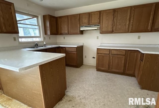 210 N State St, Christopher, IL 62822 - kitchen with under cabinet range hood, a peninsula, brown cabinets, and a sink