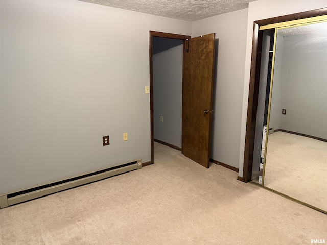 15 Dunn Ln, Goreville, IL 62939 - unfurnished bedroom with light carpet, baseboard heating, a textured ceiling, a closet, and baseboards