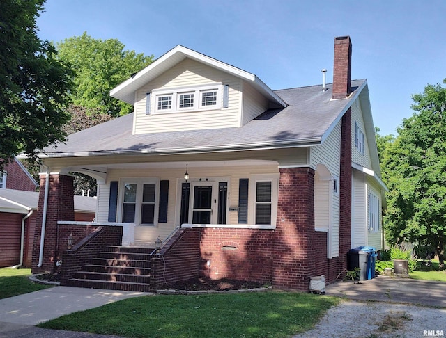 704 S Washington St, Mcleansboro, IL 62859 - bungalow-style home featuring a chimney, brick siding, covered porch, and a front lawn