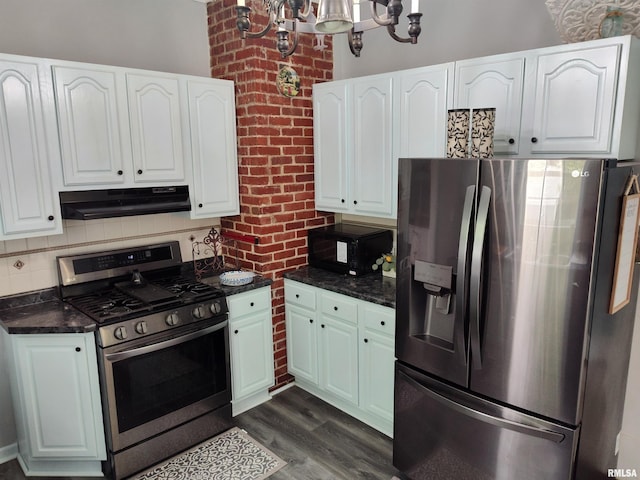 704 S Washington St, Mcleansboro, IL 62859 - kitchen with appliances with stainless steel finishes, under cabinet range hood, white cabinetry, a chandelier, and brick wall