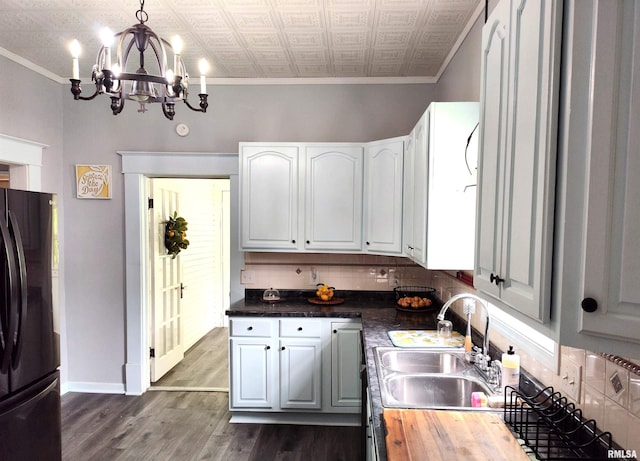 704 S Washington St, Mcleansboro, IL 62859 - kitchen featuring a sink, freestanding refrigerator, a chandelier, crown molding, and dark wood-style floors