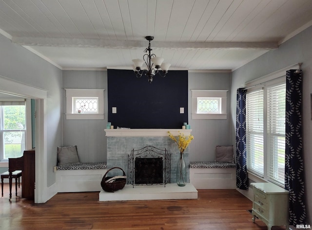 704 S Washington St, Mcleansboro, IL 62859 - living room featuring wooden ceiling with exposed beams, healthy amount of natural light, wood finished floors, a chandelier, and a fireplace with raised hearth