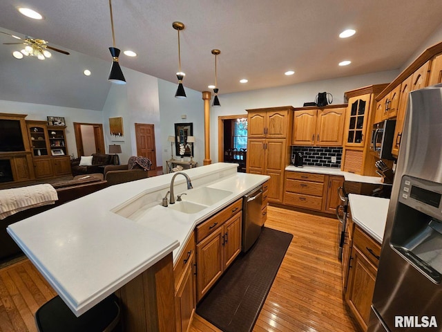 9 Fawn Dr, Fairfield, IL 62837 - kitchen with stainless steel appliances, open floor plan, a sink, light countertops, and brown cabinetry