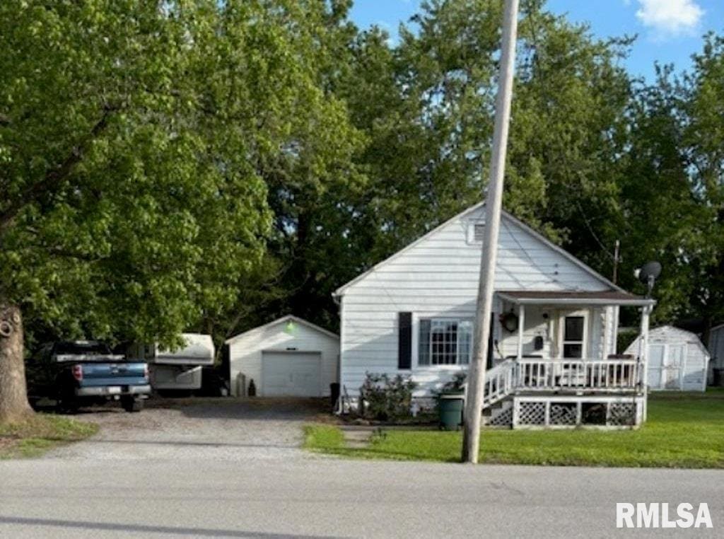 1505 W Chestnut St, Marion, IL 62959 - view of front facade with covered porch, a garage, driveway, and a front lawn
