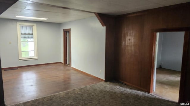 608 N Otis St, Marion, IL 62959 - unfurnished room featuring arched walkways, wood finished floors, wood walls, and baseboards