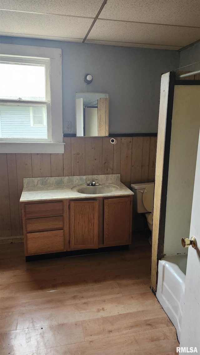 608 N Otis St, Marion, IL 62959 - bathroom with toilet, vanity, wood finished floors, a drop ceiling, and washtub / shower combination