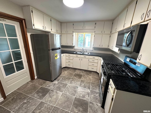 1318 E 4th St, Centralia, IL 62801 - kitchen featuring stainless steel appliances, a sink, dark countertops, and dark stone finish flooring