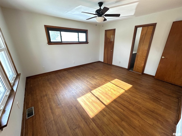 1318 E 4th St, Centralia, IL 62801 - unfurnished bedroom with wood finished floors, two closets, baseboards, and ceiling fan