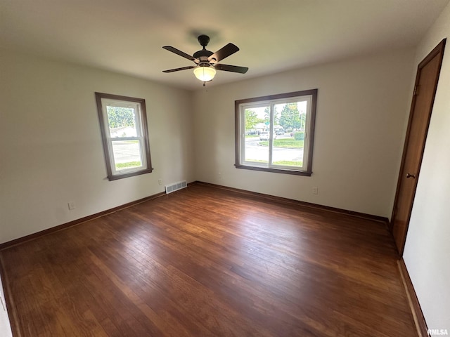 1318 E 4th St, Centralia, IL 62801 - unfurnished room featuring healthy amount of natural light, dark wood-style floors, baseboards, and ceiling fan