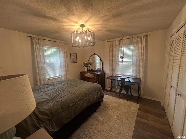 1150 Lakeview Dr, Creal Springs, IL 62922 - bedroom with wood finished floors, a chandelier, a textured ceiling, a closet, and baseboards