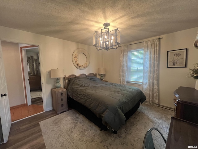 1150 Lakeview Dr, Creal Springs, IL 62922 - bedroom with a chandelier, wood finished floors, a textured ceiling, and baseboards