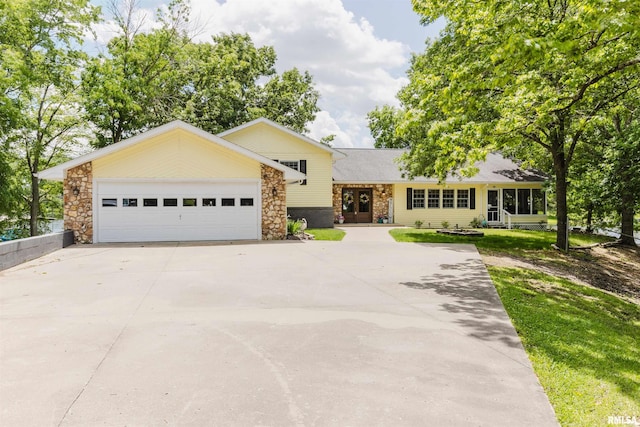 12897 Egypt Shores Dr, Creal Springs, IL 62922 - tri-level home featuring driveway, a garage, stone siding, and a front yard