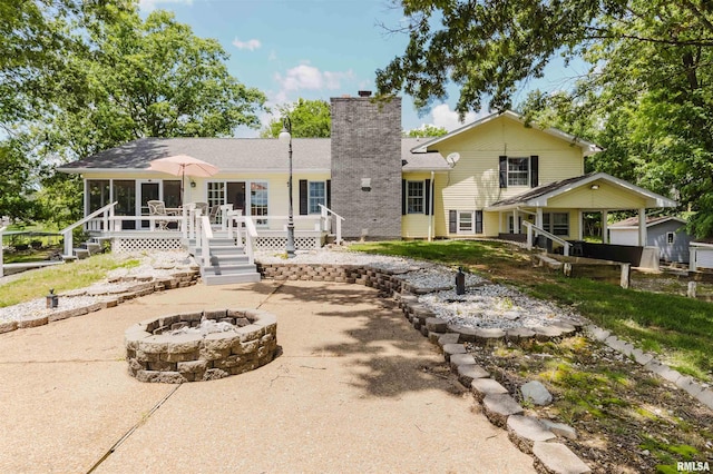 12897 Egypt Shores Dr, Creal Springs, IL 62922 - rear view of property featuring a fire pit, a chimney, a sunroom, a patio area, and a wooden deck