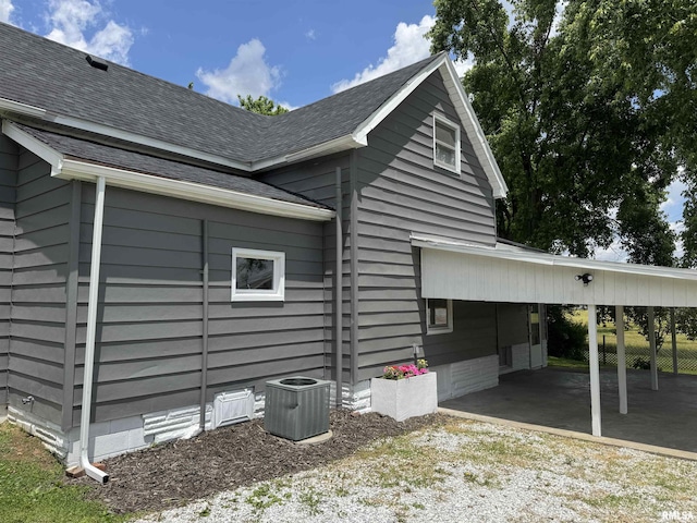 6984 Washington St, Mulkeytown, IL 62865 - view of side of home featuring a carport, central air condition unit, driveway, and a shingled roof