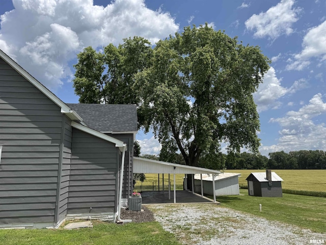 6984 Washington St, Mulkeytown, IL 62865 - view of property exterior featuring a lawn, driveway, an attached carport, central AC unit, and roof with shingles