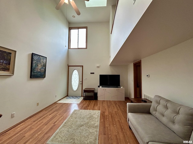 108 N Gordon Ln, Carbondale, IL 62901 - living room with a towering ceiling, a ceiling fan, healthy amount of natural light, light wood-style floors, and baseboards