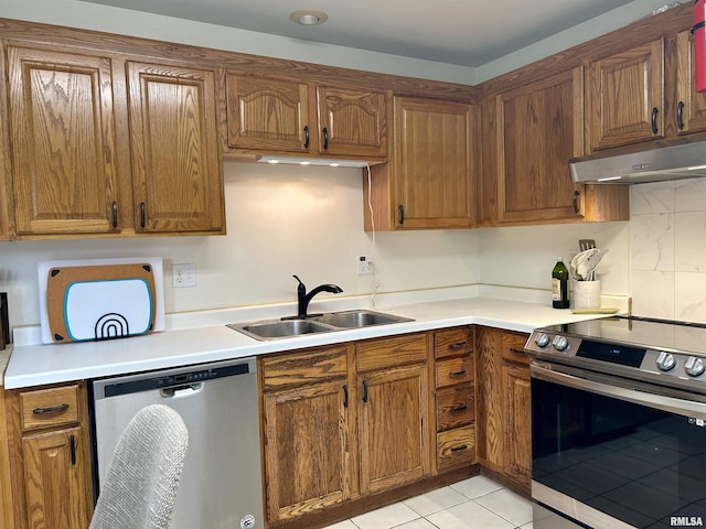 108 N Gordon Ln, Carbondale, IL 62901 - kitchen with stainless steel appliances, under cabinet range hood, a sink, brown cabinets, and light tile patterned floors