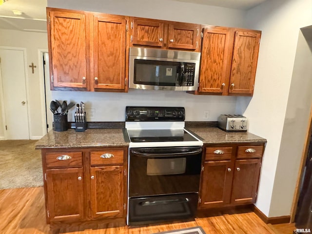 310 Williford Rd, Jonesboro, IL 62952 - kitchen featuring stainless steel microwave, range with electric stovetop, light wood-style flooring, and brown cabinets