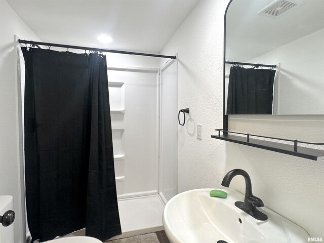 1924 N 7th St, Murphysboro, IL 62966 - bathroom with a sink, a shower with curtain, a textured wall, and toilet