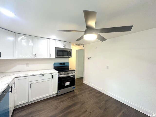 1924 N 7th St, Murphysboro, IL 62966 - kitchen with appliances with stainless steel finishes, dark wood finished floors, white cabinetry, light stone counters, and baseboards