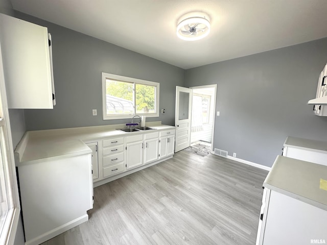 1206 E 2nd St, Centralia, IL 62801 - kitchen featuring a sink, white cabinetry, light wood-style flooring, and light countertops
