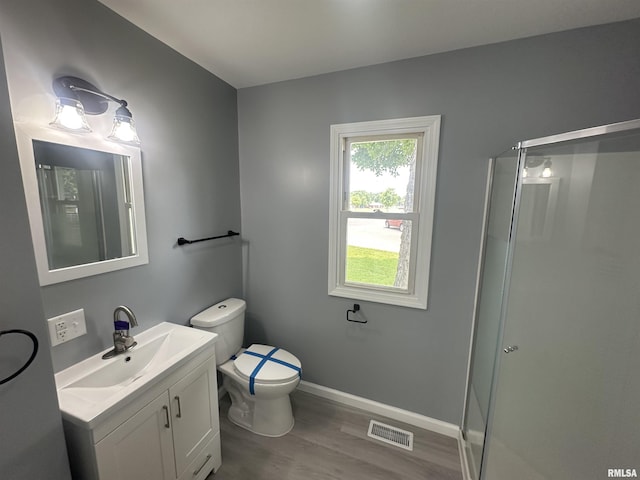 1206 E 2nd St, Centralia, IL 62801 - full bathroom with wood finished floors, vanity, a stall shower, toilet, and baseboards